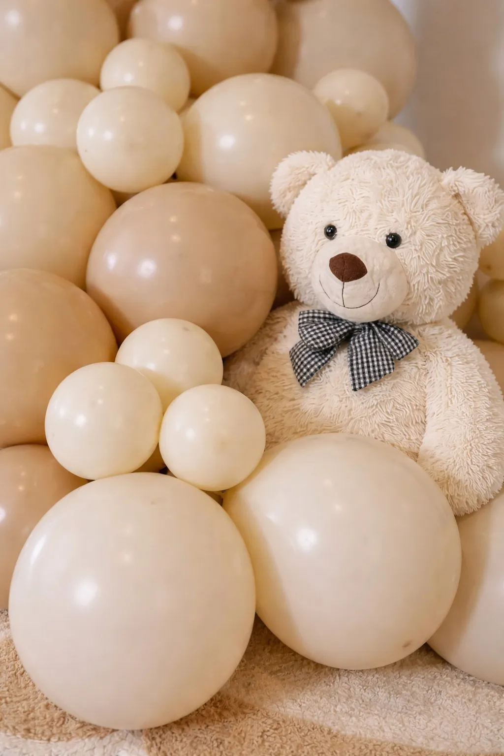 Detalle globos beige y crema con osito de peluche