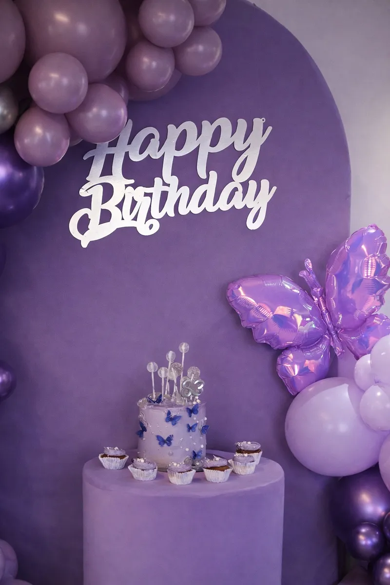 Detalle de pastel y mariposa en decoración morada